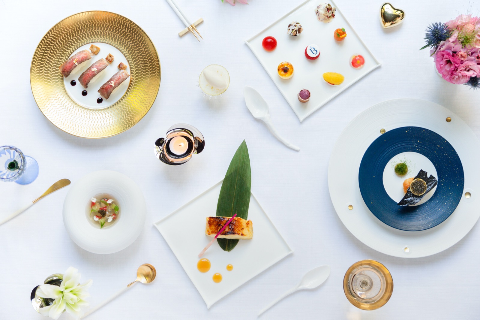 Fine dining spread — gold plates, exquisite courses, overhead table view
